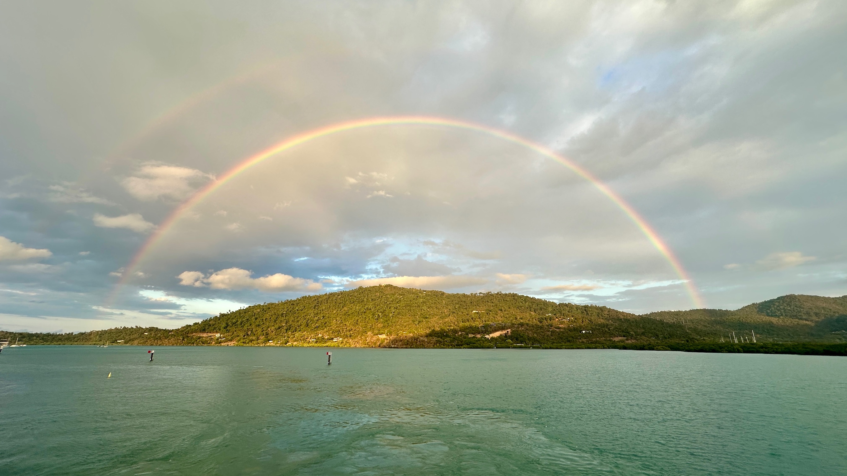 A double rainbow over the sea from a coastal headland